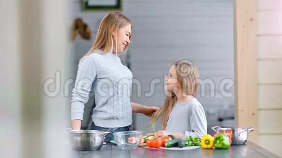 妈妈和她女儿正在用蔬菜做素食晚餐视频的预览图