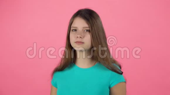 女孩在画室用手机对着粉红色背景说话慢动作视频的预览图