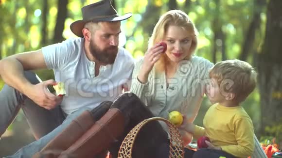 阳光公园的幸福家庭一起快乐的消遣家人吃新鲜苹果健康快乐的家庭时光有趣搞笑视频的预览图