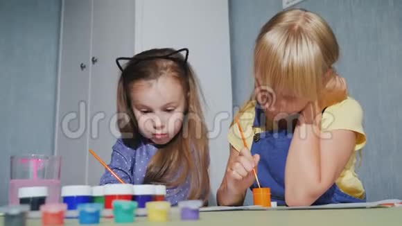 两个女孩并排坐在一起用水彩作画视频的预览图