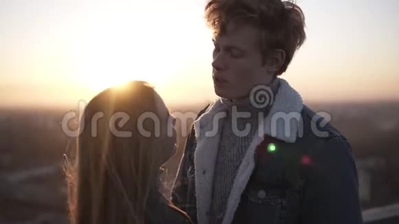 年轻的金发男孩和她的长发女朋友站在罗格在日出拥抱好好享受视频的预览图