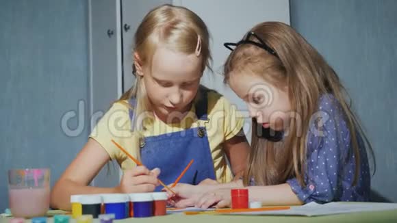 两个姐妹热情地画着水彩颜料视频的预览图