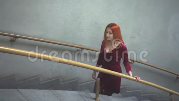 头发红的女孩爬楼梯视频的预览图