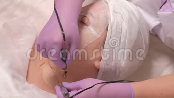 在美容诊所的接待处闭着眼睛的中年妇女美容师双手戴着紫丁香手套做了一个微型手术视频的预览图