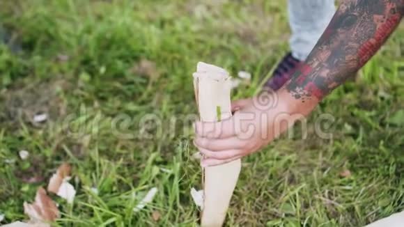 一个手臂上有纹身的人正试图用斧头砍木头视频的预览图