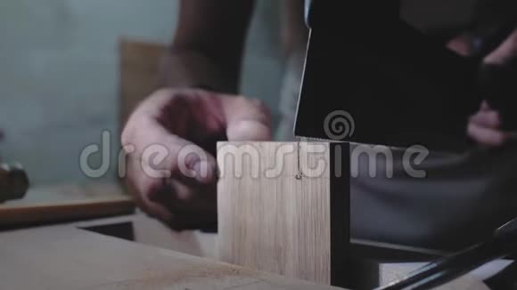 特写木匠用手锯锯木板木工在木制细节上做燕尾4k4k录像慢慢视频的预览图