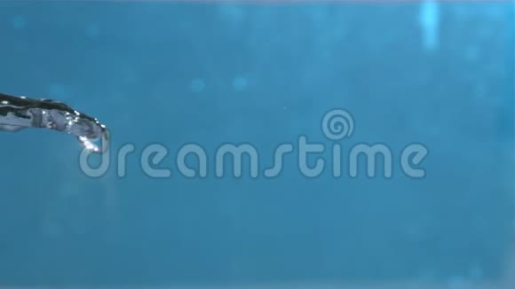 在蓝色背景特写镜头上以1500fps高速喷射空气中的淡水视频的预览图