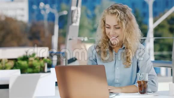 年轻的商务女性在视频会议或视频聊天上交谈使用笔记本电脑坐在夏季露台上视频的预览图