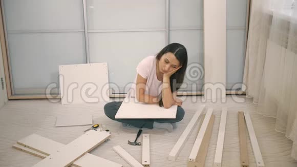悲伤的女人不能组装家具视频的预览图