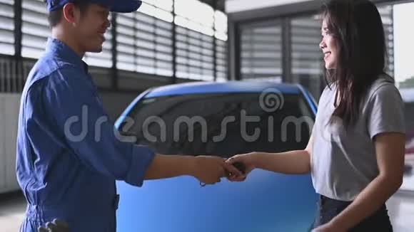 汽车修理工在汽车修理厂购买或维修后将汽车钥匙交给女顾客驾驶视频的预览图