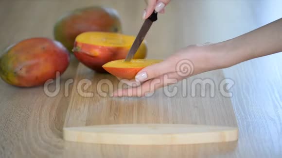 女厨师她的手在木切割板上切芒果视频的预览图