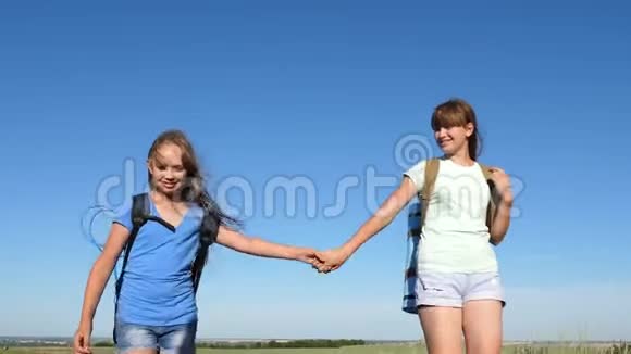团队合作游客青少年女孩们女旅行者牵着手走在蓝天的背景上特写镜头妇女视频的预览图