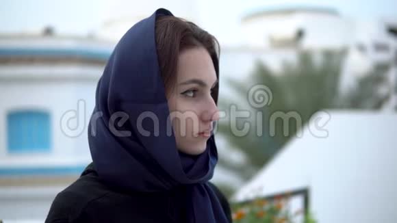 阿拉伯头巾的年轻女子一个女人在看镜头在阿拉伯之家的背景下视频的预览图