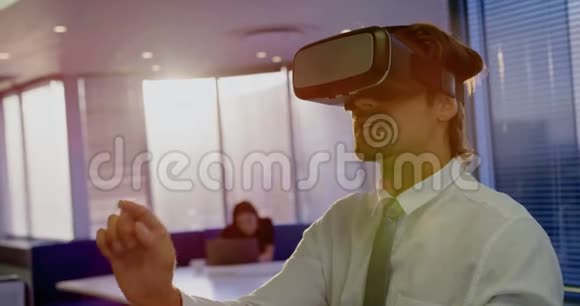 现代办公室使用虚拟现实耳机的年轻高加索男性高管的正面视图4k视频的预览图