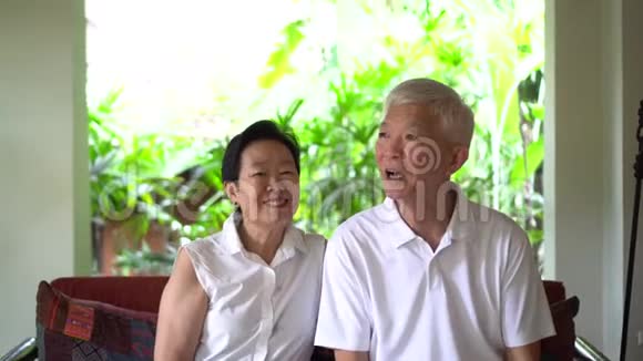 亚洲老人坐在度假村的秋千沙发上享受假期视频的预览图