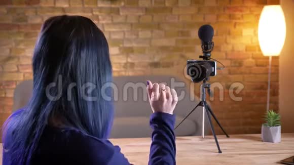 年轻有魅力的高加索女性视频博主在现场直播和打手势时在镜头前交谈视频的预览图