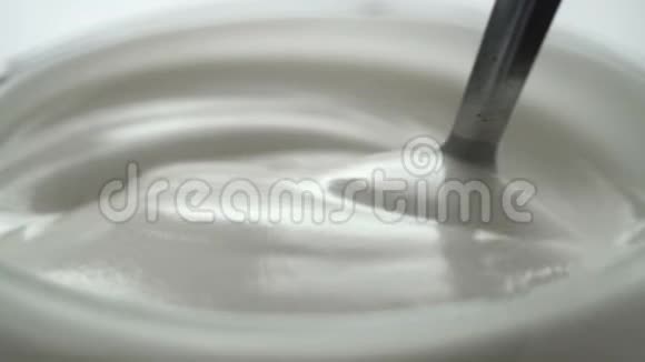 视频拍摄在杯中用勺子搅拌酸奶的慢动作视频的预览图