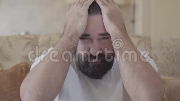 大胡子的肖像用大手按摩他的头脸上贴着痛苦的表情成年男子视频的预览图