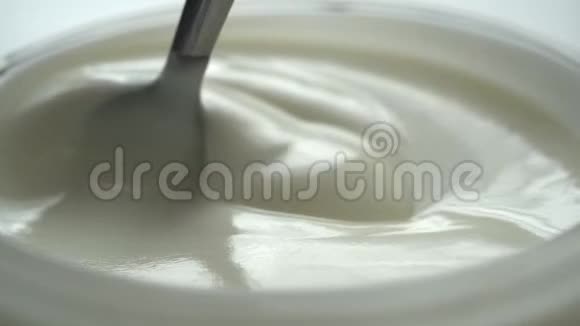 视频拍摄在杯中用勺子搅拌酸奶的慢动作视频的预览图