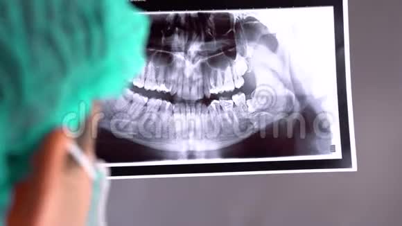 牙科医生检查牙齿x光片在一个招待会上牙医牙医在平板电脑上给她X光视频的预览图