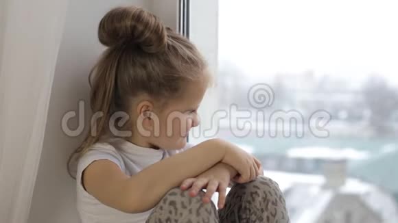 小女孩微笑着坐在窗边望着窗外视频的预览图