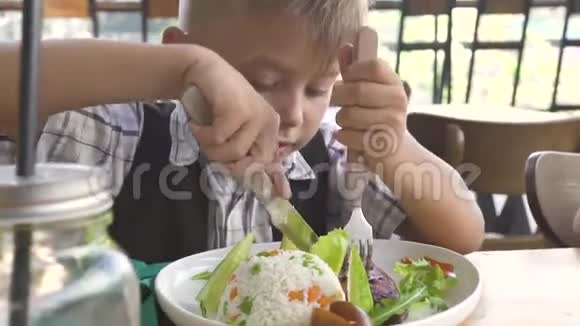 可爱的男孩和女孩在儿童餐厅吃食物小女孩和男孩在餐馆吃饭兄妹吃东西视频的预览图