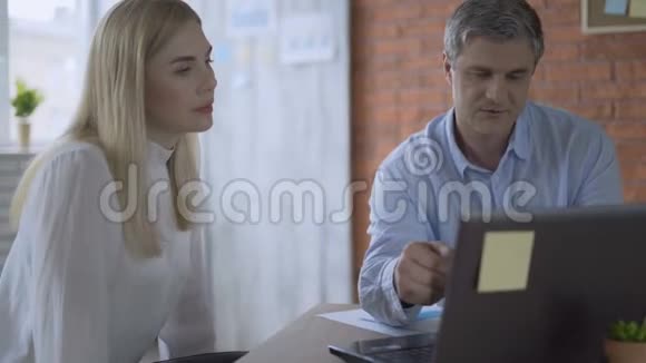 工作妇女在笔记本电脑上打字并将结果显示给伴侣4K视频的预览图