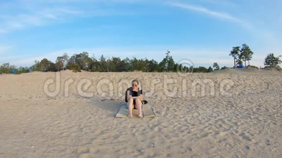 女孩坐在海边沙滩上画画视频的预览图