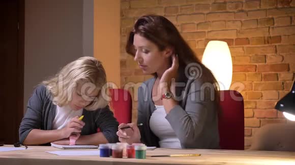 年轻的白种人母亲在舒适的家庭里评估她的小漂亮女儿的数学技能的特写照片视频的预览图