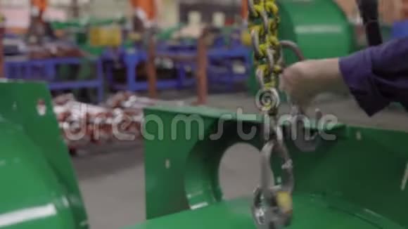 没有个人防护设备的手工工人在工程工厂里粘着磨损的金属挂钩细节绿色视频的预览图