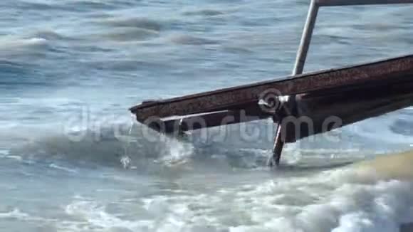 在肮脏的海洋中一个被摧毁的生锈的古老的金属结构的特写视频的预览图