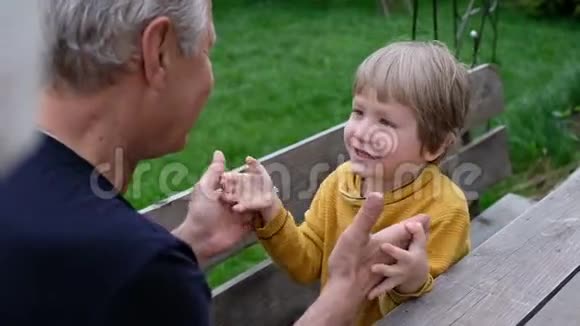 可爱的小男孩和他的祖父玩耍夏天在户外视频的预览图