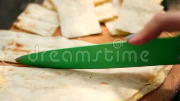 在大自然的野餐中人们用绿刀把皮塔面包切成小块视频的预览图