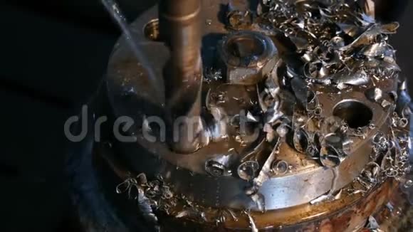 车床上金属零件钻孔加工过程特写钻孔机上水制造视频的预览图