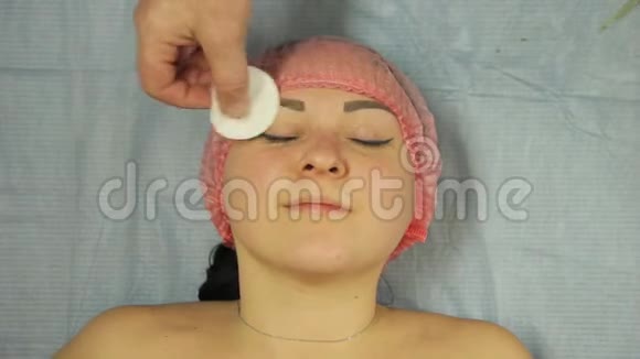 美容师的手用棉垫滋润女人脸视频的预览图
