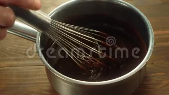 在金属锅里用手搅拌厚厚的巧克力混合填料视频的预览图