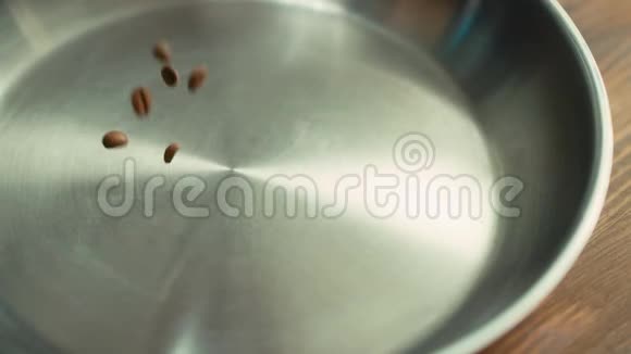 烤咖啡豆缓慢地落在金属碗表面视频的预览图