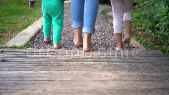 光脚的家庭探索新的感觉在脚木和小石径视频的预览图