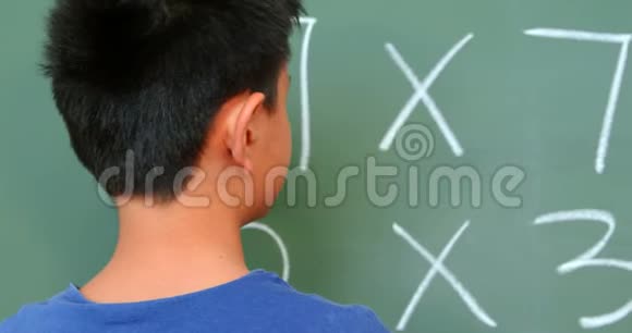 亚洲小学生在学校教室用黑板解决数学问题的后视图视频的预览图