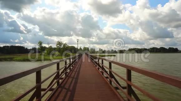 走在连接两个湖岸的最长的人行桥上视频的预览图