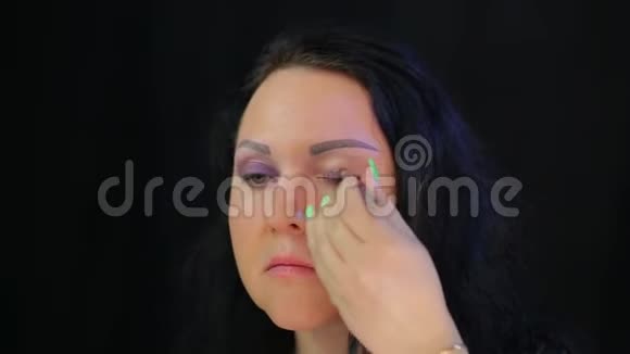一个女人用一抹深紫色的阴影遮住她的眼睛视频的预览图