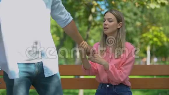 男人把心烦意乱的女友独自留在公园的长凳上走开分手视频的预览图