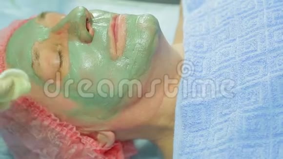 一位女性美容师用棉垫从一个男人的脸上取出一个治疗泥面膜视频的预览图