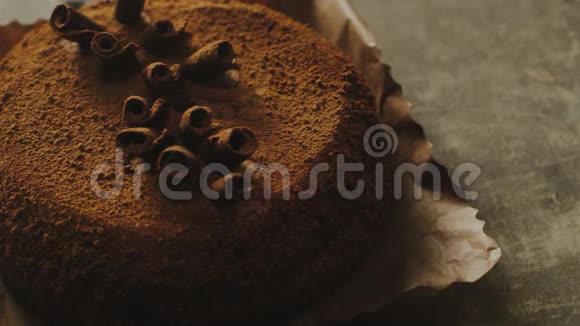 特写女人用巧克力刨花装饰蛋糕的慢动作视频的预览图