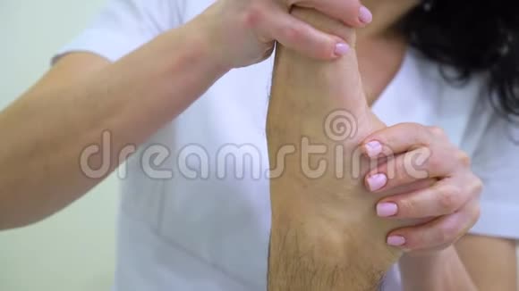 女性按摩师为男性客户做足底和小腿按摩视频的预览图