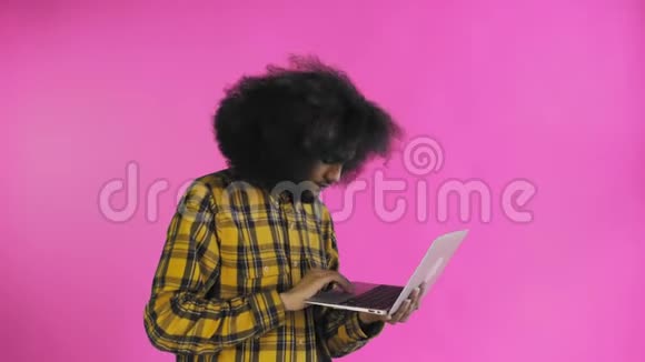 快乐的非裔美国人使用笔记本电脑微笑着离开紫色背景情感概念视频的预览图