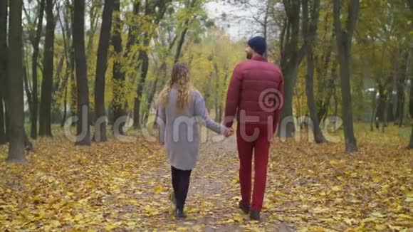 可爱的情侣在秋天的大自然中漫步视频的预览图