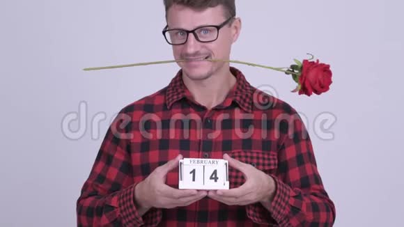 快乐的留胡子的嬉皮士男人拿着日历块准备情人节视频的预览图