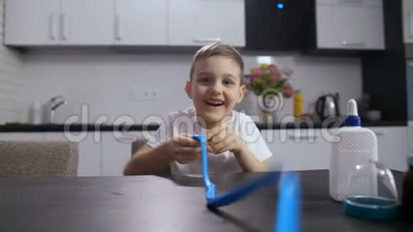 微笑的男孩在玩长而手工的黏液视频的预览图