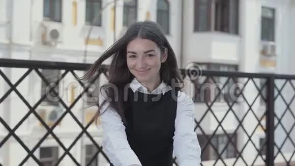 一位漂亮的年轻女子在露台上欢快地跳舞看着镜头的肖像女商人收到了好消息视频的预览图
